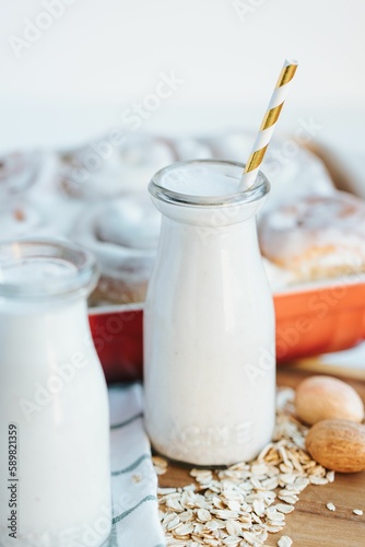 Vertical of the fresh milkshake and cinnamon rolls on the put on the wooden table