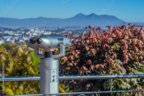 A telescope with a view of the city of Dalat Vietnam mountains flowers the background