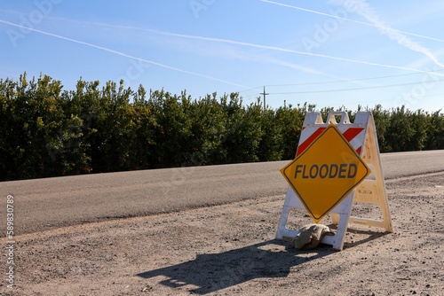 Orange warning flooded sign on a dusty road in Fresno, CA