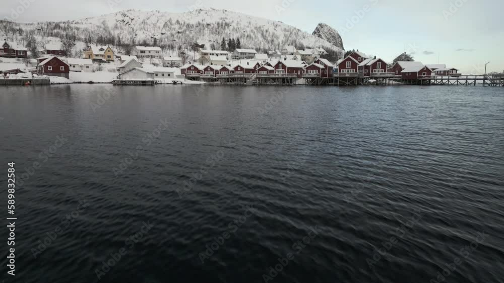 Flying Towards Reine Municipality In Moskenesøya, Norway During Winter - drone shot Flying Towards Reine Municipality In Moskenesøya, Norway During Winter - drone shot