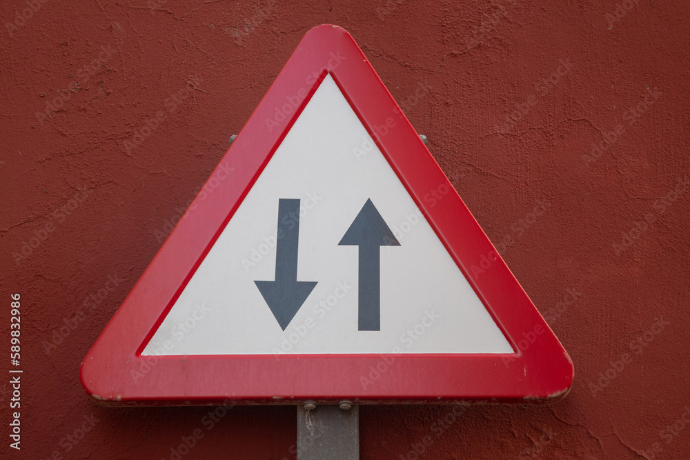 Two Way Traffic Sign on Red Wall