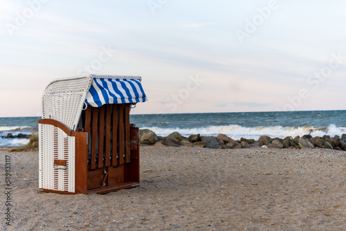 Strandkorb mit Strand und Steinen an der Ostsee