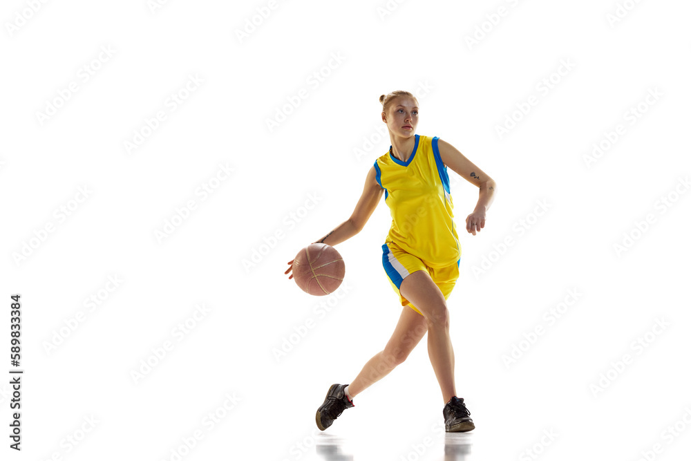 Competition. Young sportive girl, basketball player in uniform training, playing against white studio background. Concept of professional sport, hobby, healthy lifestyle, action and motion