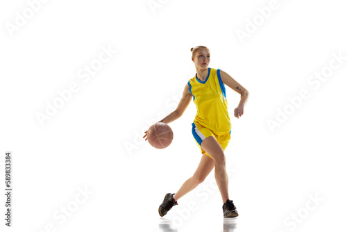 Competition. Young sportive girl, basketball player in uniform training, playing against white studio background. Concept of professional sport, hobby, healthy lifestyle, action and motion