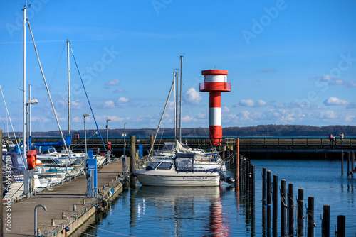 Fotografía Kleiner Leuchtturm mit Booten am Hafen an der Ostsee