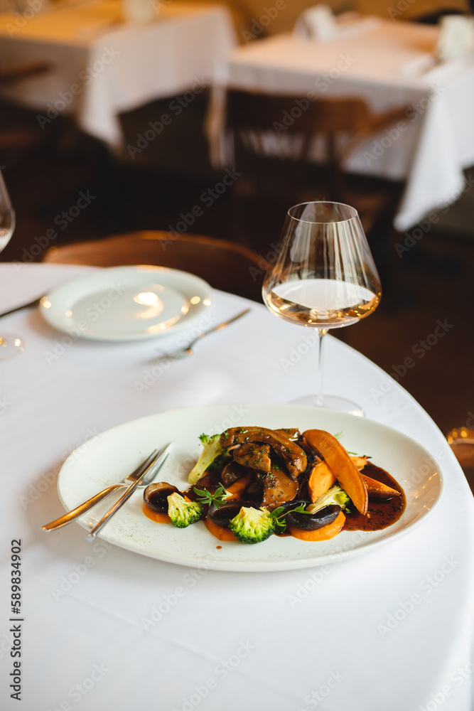 Grilled vegetables in a large white plate. A glass of rose wine on a light background. Grilled vegetables in a large white plate. A glass of rose wine on a light background.