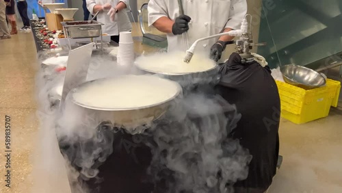 a chef making ice cream with liquid nitrogen, vapours falling from the large bowls  photo