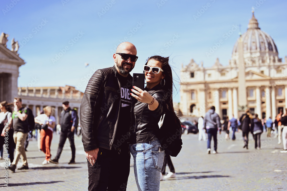 Happy smiling beautiful Tourists couple traveling at Rome, Italy, poses and making photos in front of Vatican City at, Rome, Italy.Concept of Italian gastronomy and travel. Italian couple having Happy smiling beautiful Tourists couple traveling at Rome, Italy, poses and making photos in front of Vatican City at, Rome, Italy.Concept of Italian gastronomy and travel. Italian couple having