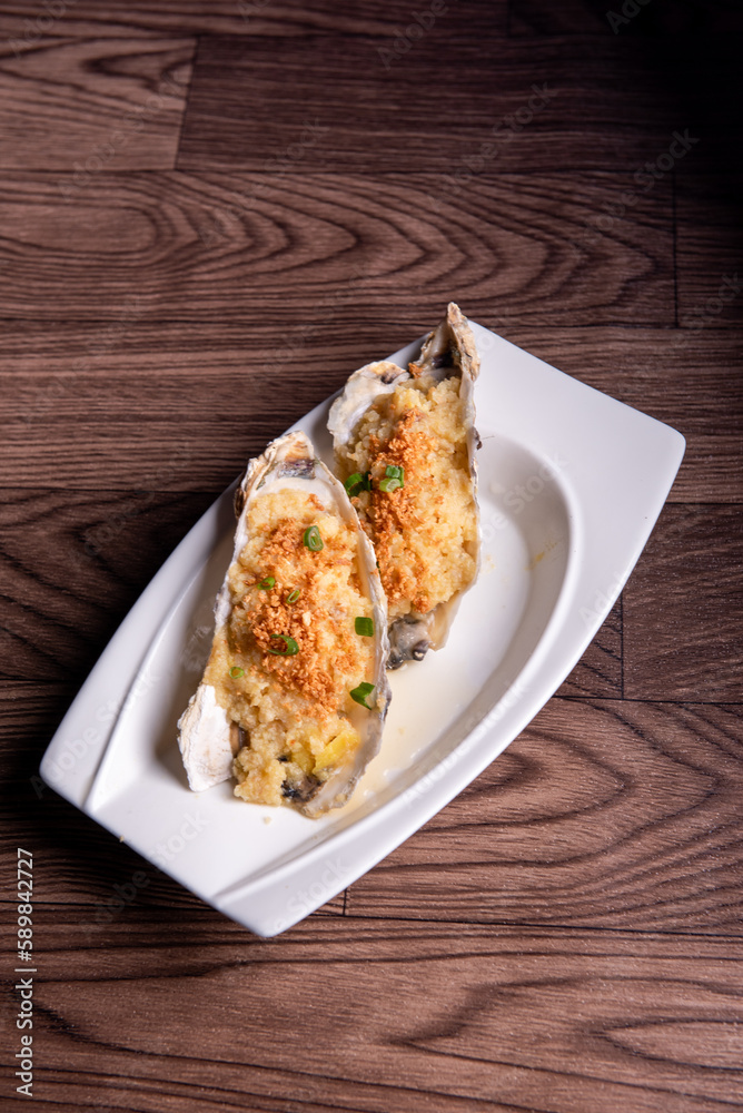 fresh western seafood steamed 2 big oyster shell with garlic ginger sauce in white plate on wood table luxury halal food fine dining restaurant menu fresh western seafood steamed 2 big oyster shell with garlic ginger sauce in white plate on wood table luxury halal food fine dining restaurant menu