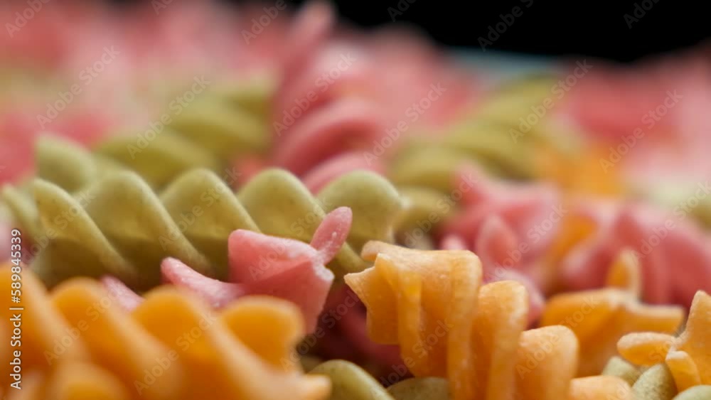 Rice vegetable pasta in the form of spirals rotate on a black background. Healthy gluten-free vegan pasta Rice vegetable pasta in the form of spirals rotate on a black background. Healthy gluten-free vegan pasta