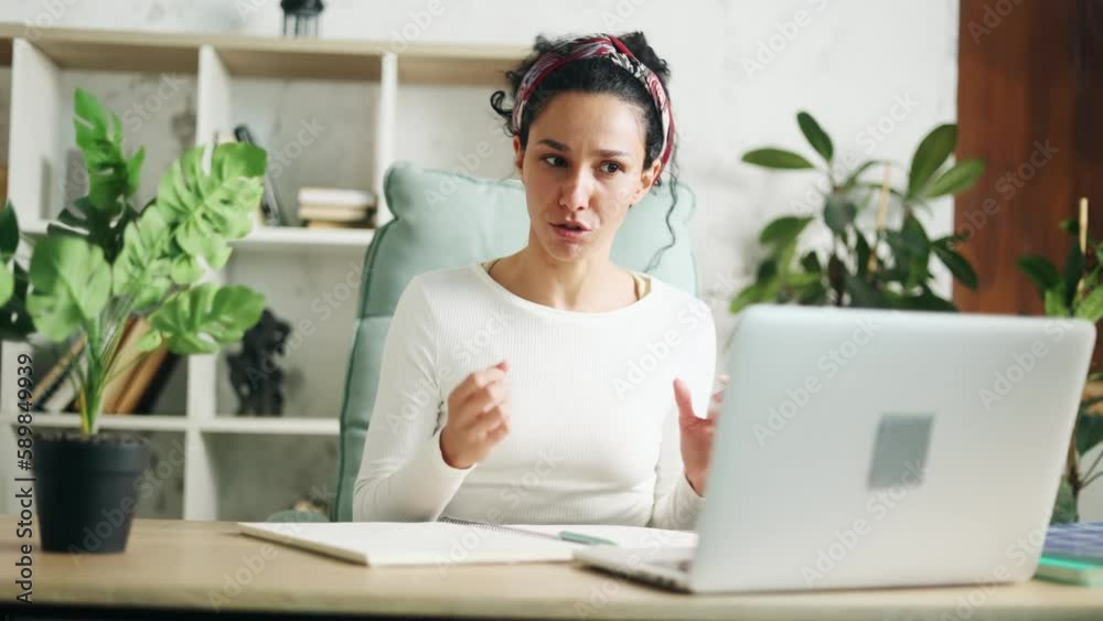 Irritated arguing young hispanic woman looking at laptop screen yelling indoors Angry nervous female expressing negative emotion and shows fists by online conference meeting Bad conflict conversation Irritated arguing young hispanic woman looking at laptop screen yelling indoors Angry nervous female expressing negative emotion and shows fists by online conference meeting Bad conflict conversation