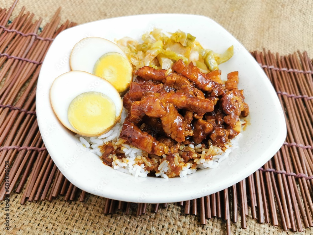 Braised Pork Rice with boiled egg served dish isolated on table top view of thai food
