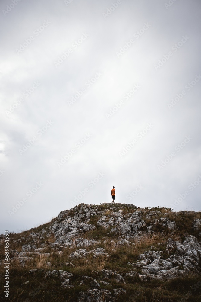Vertical shot of a man standing at the top of the Durmitor mountain in Zabljak, Montenegro