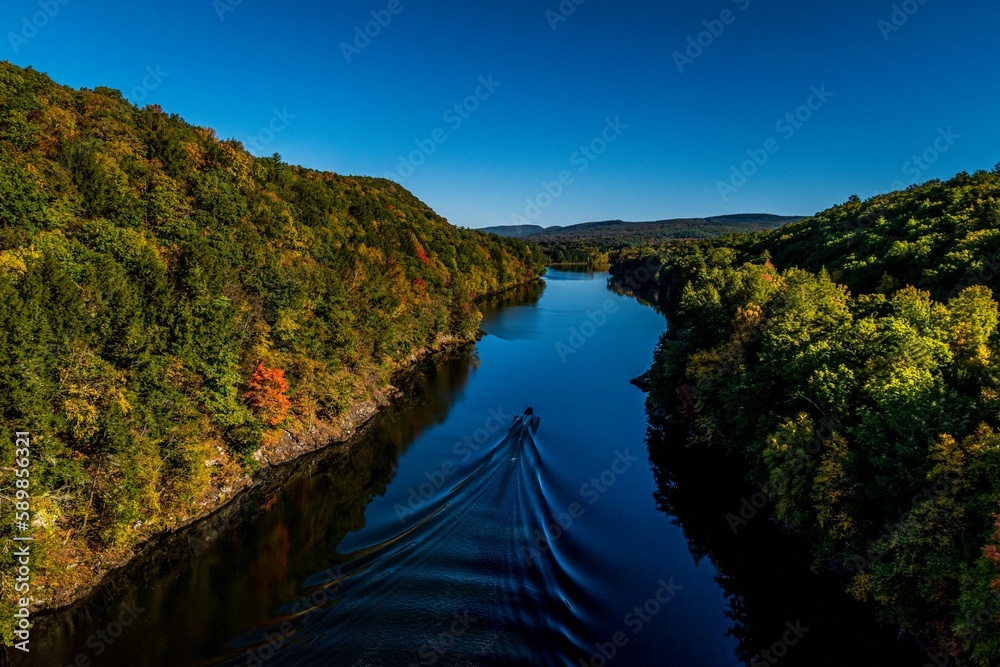 Boat in a tranquil river surrounded by a green forest in western Massachusetts