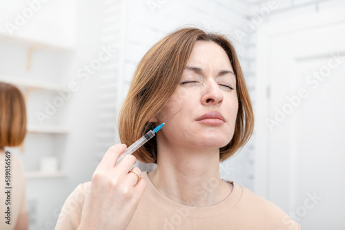 Woman doing botox herself at home