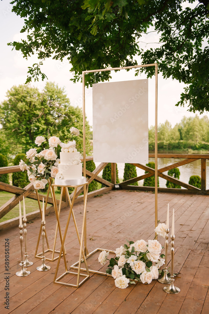 Holiday or wedding decor with beautiful compositions of white roses with an empty background and a white cake in nature
