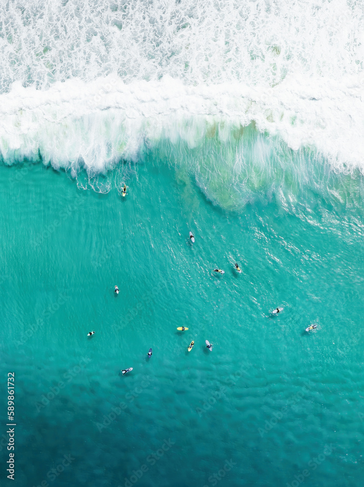 View from above, stunning aerial view of a person surfing on a turquoise ocean. Fuerteventura, Canary Islands, Spain.