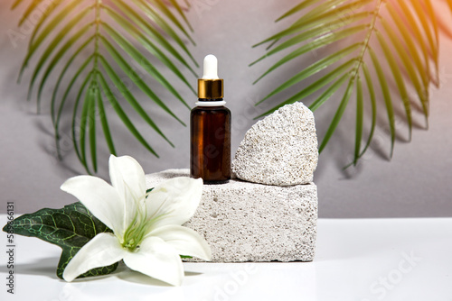 Spa and wellness setting with stones  lily flower and oil sereum for face beauty concept