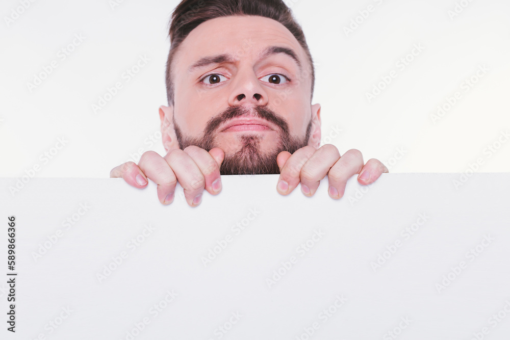 Happy young bearded man showing and displaying white empty placard ready for your text or product or ad Happy young bearded man showing and displaying white empty placard ready for your text or product or ad