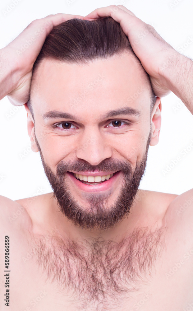 Obraz premium Handsome, attractive, brutal, modern, manly, confident, naked man touching his perfect, ideal face skin, looking at camera and posing isolated on white background after bath
