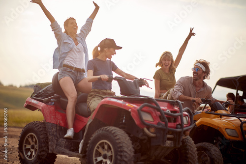 A group of cheerful friends are in a good mood while riding quads in the nature. Riding, nature, friendship, activity