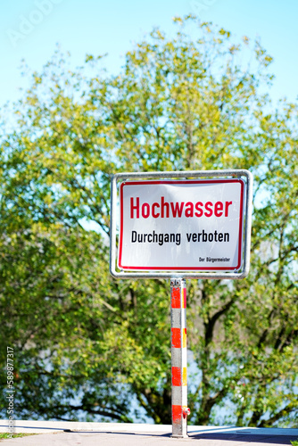 Flood high tide notice info sign on the sidewalk blocked, as a warning info board in German, German language 