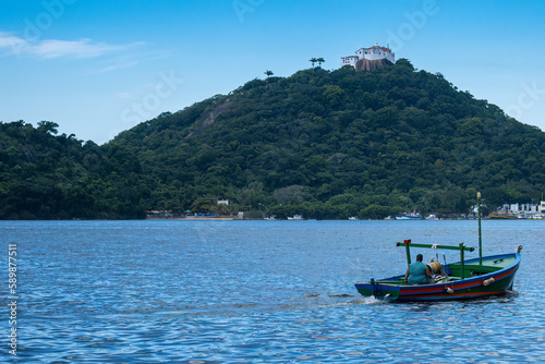 Penha Convent in the background and a fisherman driving a boat in the foreground.