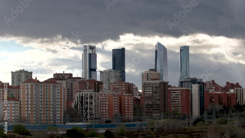 Time lapse of the four tallest skyscrapers in the city of Madrid during a cloudy afternoon, rising above the surrounding residential buildings, 4k resolution