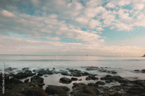 Long exposure of a sunset by the sea and a rocky coast