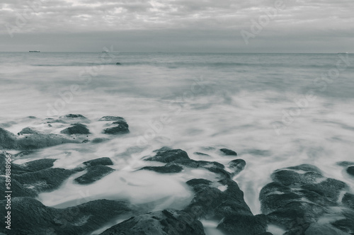 A beautiful long exposure shot of waves crashing onto the rocky shore © harry