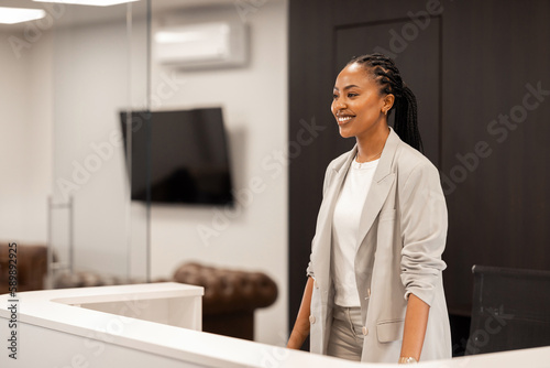 The young African-American female receptionist greets the guests with a big sincere smile. © Stock Rocket