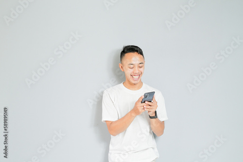a young Asian man is smiling while on a video call
