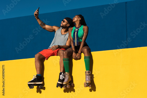 Cheerful couple with roller skating outside. Fun sexy boyfriend and girlfriend taking selfie photo.