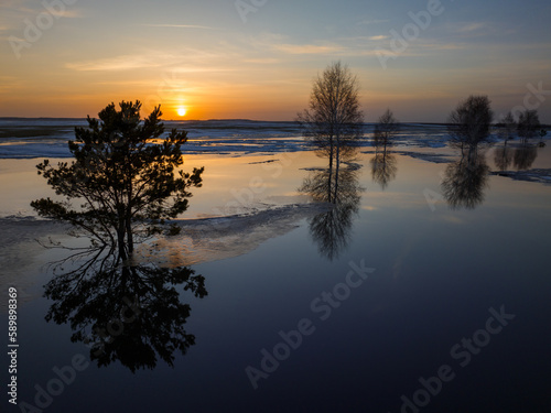 The last rays of the setting sun illuminate the flooded fields. Kazakh steppe during the spring flood.
