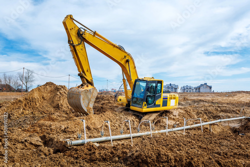 Excavator dig the trenches at a construction site. Trench for laying external sewer pipes. Sewage drainage system for a multi-story building. Digging the pit foundation
