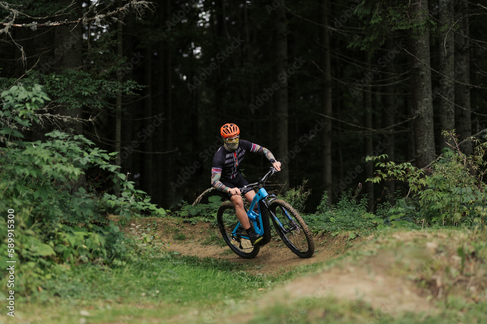Cyclist Riding the Bike in the Beautiful Mountains Down the Rock on Background. Extreme Sport and Enduro Biking Concept Cyclist Riding the Bike in the Beautiful Mountains Down the Rock on Background. Extreme Sport and Enduro Biking Concept
