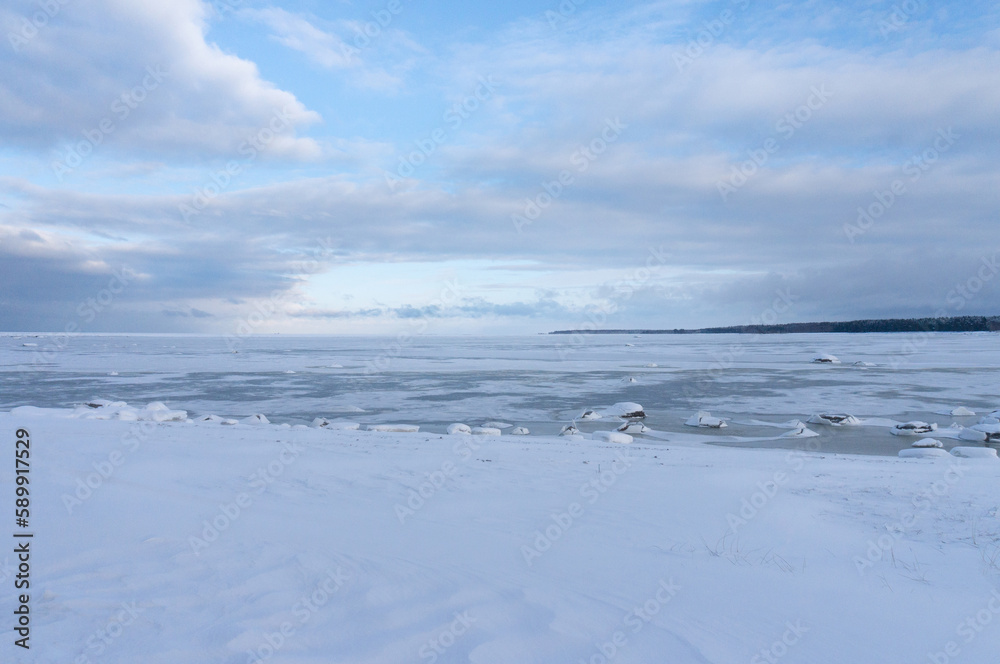 the seashore in winter. the sea is under ice and snow