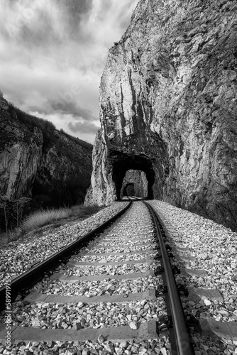 Old railway passing through short tunnels in picturesque rural scenery. Black and White photo