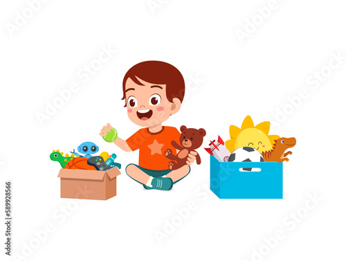 little kid put toys to box for donation