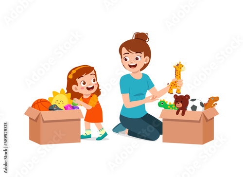little kid put toys to box for donation with mother