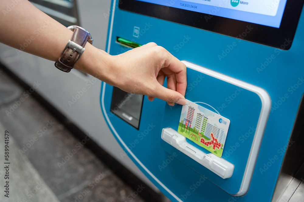 SINGAPORE APR 19, 2022 Lady's hand placing the Singapore MRT Card