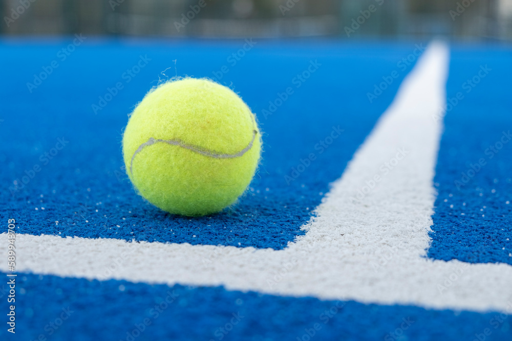 close-up shot of a ball on a blue paddle tennis court