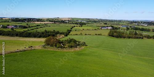 Vast green pastures for cattle in the south of Ireland. Picturesque farmland, top view. Agricultural landscape on a sunny summer day. Nature. Green grass field under blue sky photo