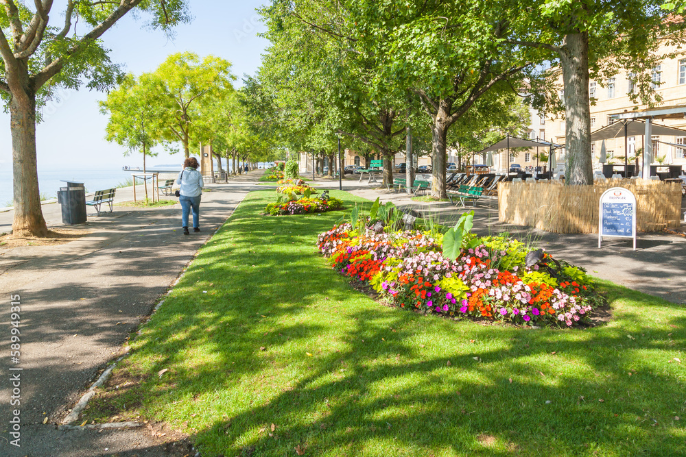  Neuchatel Lake in Switzerland is seen from the port promenade of Estavayer-le-Lac, with plants and flowers.