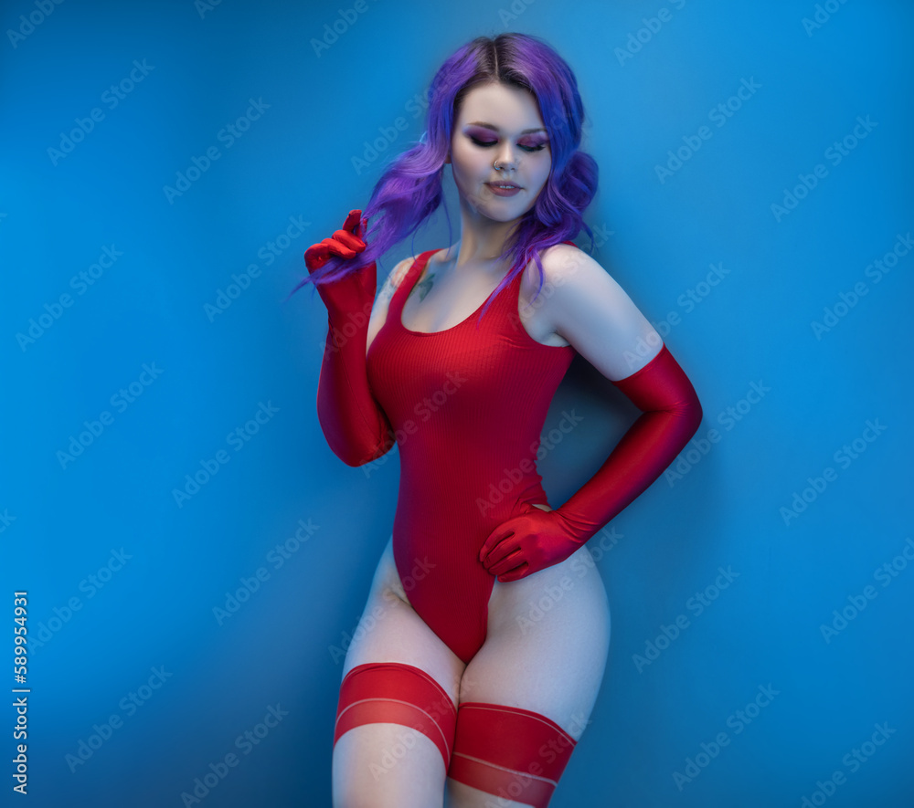 Obraz premium sexy girl in red bodysuit stockings and red gloves poses erotically against the background