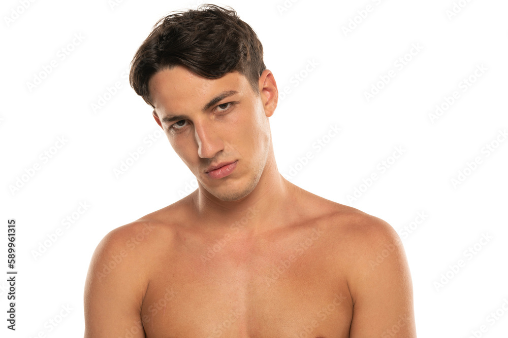 Closeup portrait of sullen half naked man 20s looking at camera isolated over white background Closeup portrait of sullen half naked man 20s looking at camera isolated over white background