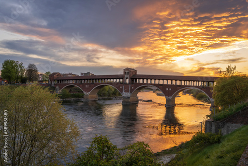 Fototapeta Naklejka Na Ścianę i Meble -  Ponte Coperto (covered bridge) over Ticino river in Pavia at sunset, Lombardy, italy.