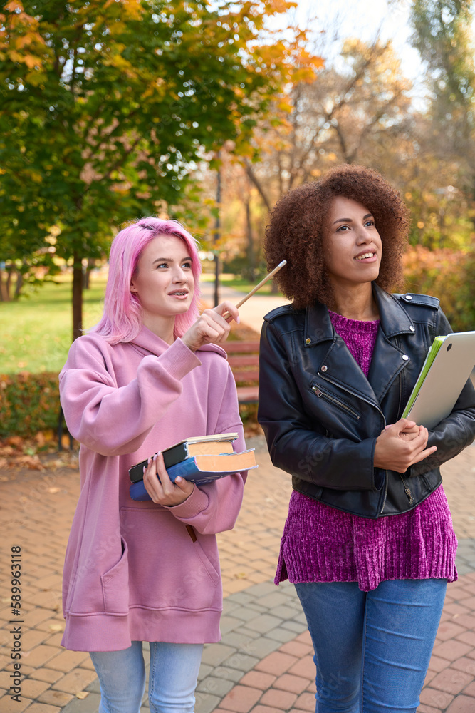 Smiling students in park staring into distance Smiling students in park staring into distance