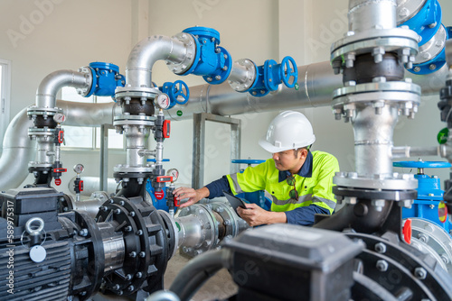 Schilderij op canvas Asian engineer inspect water pump valve fittings in a substation for the distribution of clean water at a large industrial estate