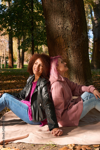 Young lesbian couple resting in public park